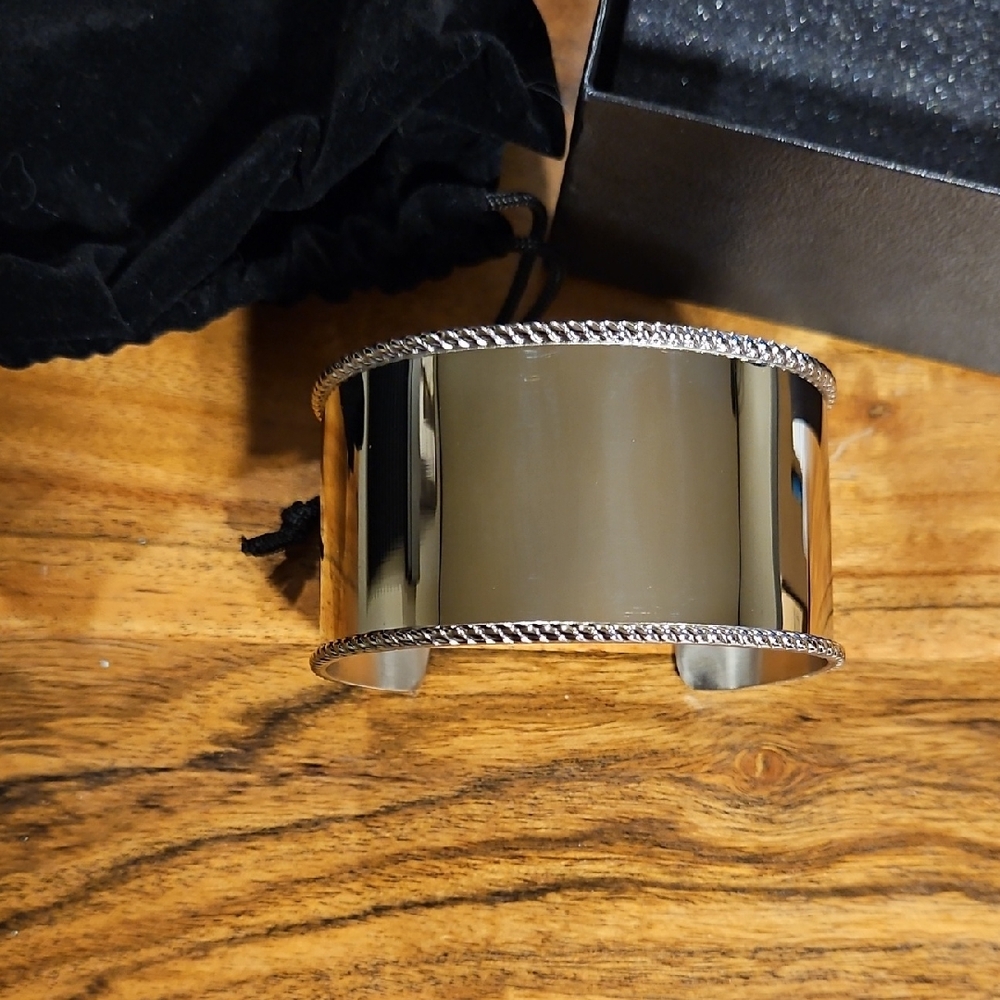 Wide stainless steel cuff bracelet with a rope-detailed edge.
